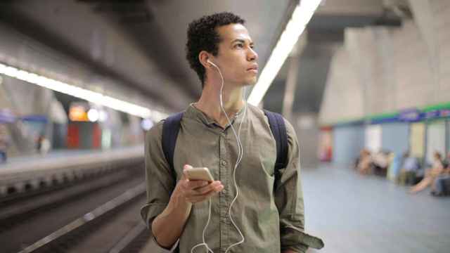 Joven escuchando podcasts en el Metro / PEXELS