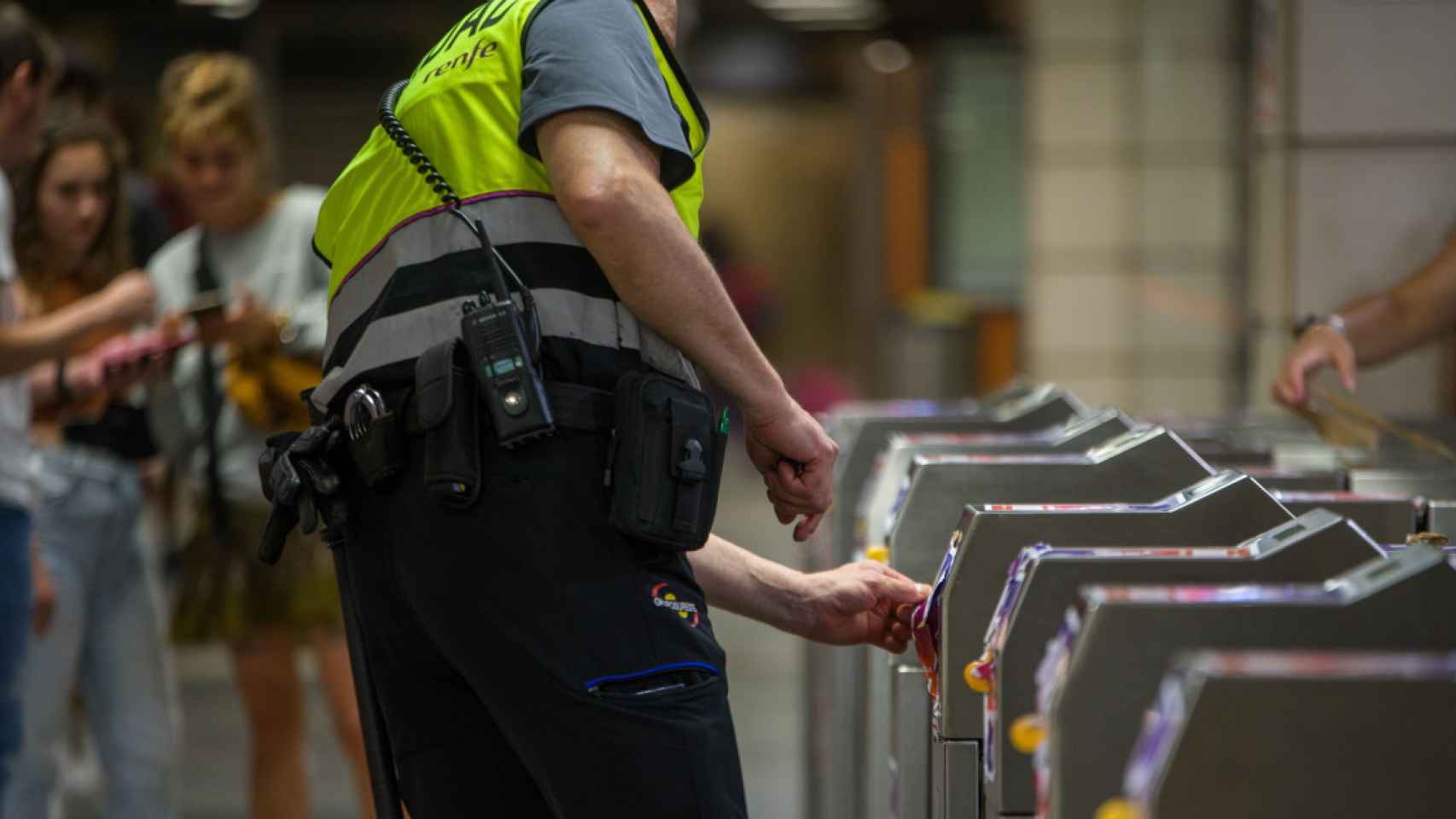 Un guardia de seguridad repara los tornos, vandalizados, en una estación de plaza de Catalunya / LORENA SOPENA - EUROPA PRESS