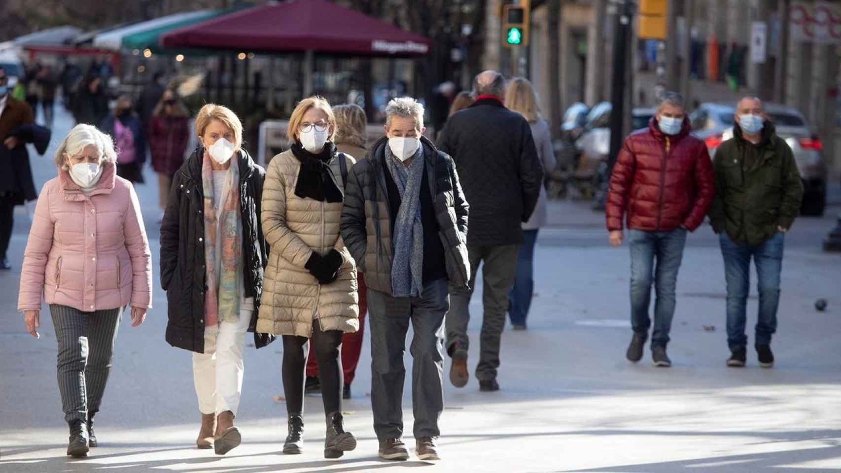 Diferentes personas caminan con la mascarilla obligatoria por una calle del centro de Barcelona / MARTA PÉREZ - EFE