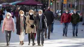Diferentes personas caminan con la mascarilla obligatoria por una calle del centro de Barcelona / MARTA PÉREZ - EFE