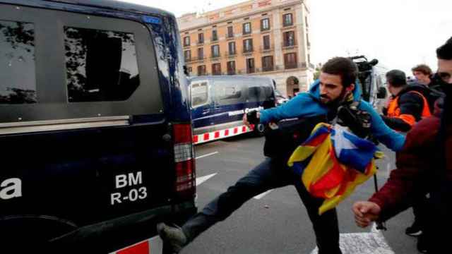 Un simpatizante independentista golpea una furgoneta de los Mossos d'Esquadra / EFE