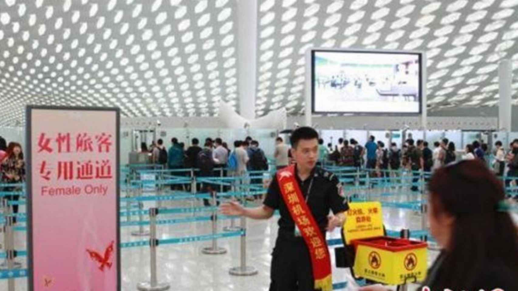 Un agente de seguridad chino muestra la entrada para un control solo para mujeres.