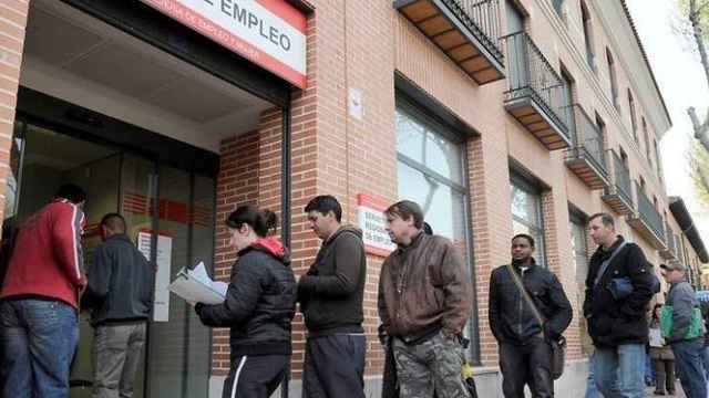 Un grupo de personas frente a una oficina de empleo por el aumento del paro