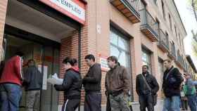 Un grupo de personas frente a una oficina de empleo por el aumento del paro