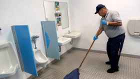 Un trabajador limpia baños públicos / EFE