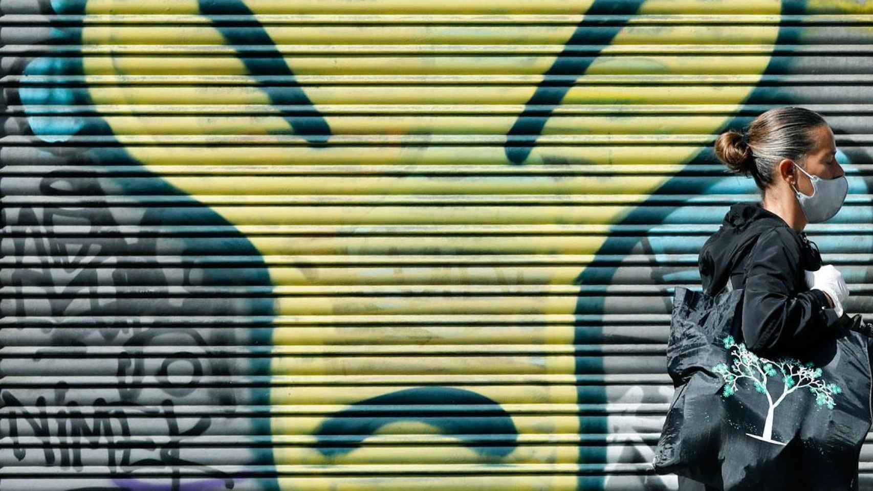 Imagen de una ciudadana con mascarilla caminando por la avenida Paral·lel de Barcelona / EFE