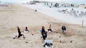 Varias personas haciendo ejercicio en la playa de Barcelona durante la pandemia de coronavirus / EFE