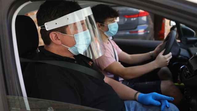 Dos personas usan mascarilla en un coche / EP