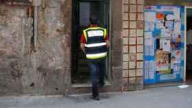 Un agente de la Guardia Urbana entra en un piso del barrio el Raval, imagen de archivo / CG