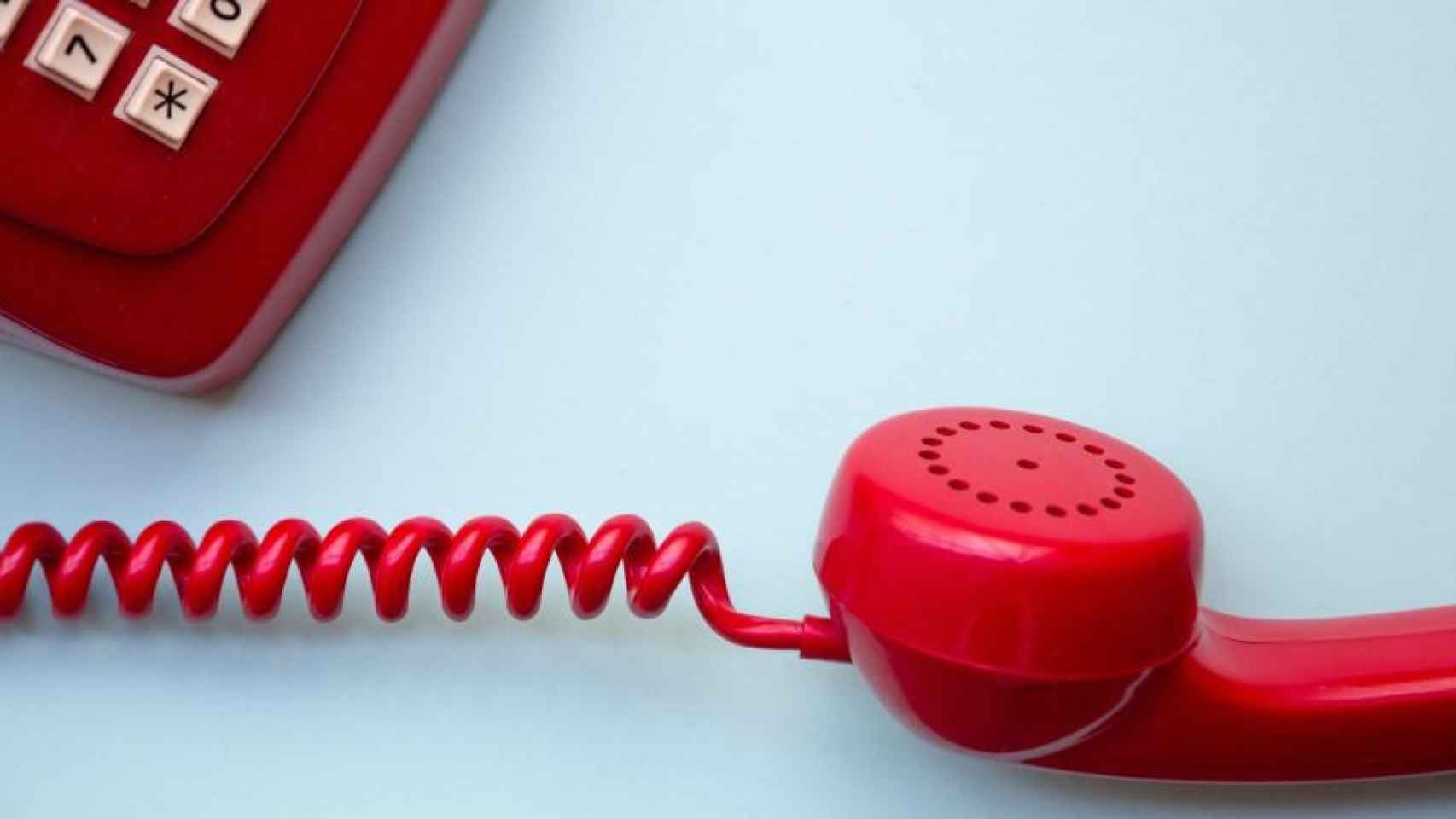 Un teléfono rojo, aparato necesario para la telefonía