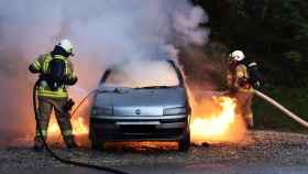Foto de un coche incendiado, con los bomberos aplicando las labores de extinción / PIXABAY