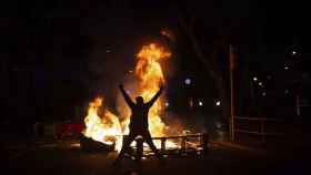 Un hombre delante una de las barricadas en llamas producidas durante la última semana de disturbios en Barcelona / EP