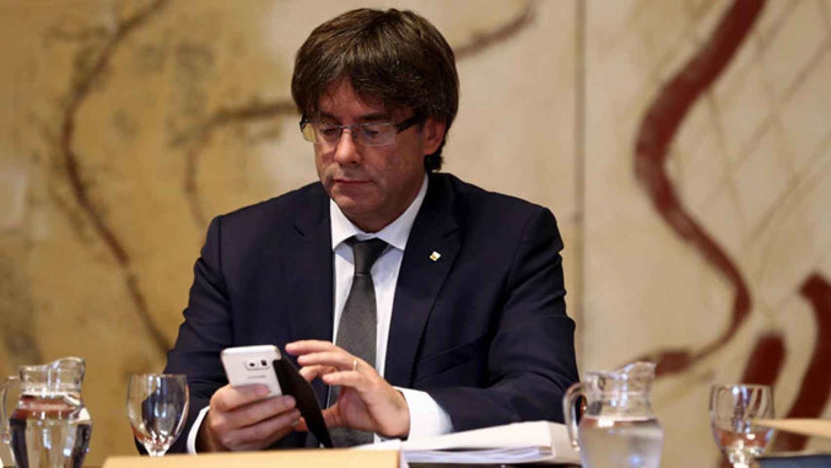 El presidente de la Generalitat, Carles Puigdemont, consulta su teléfono móvil / EFE