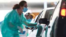 Imagen de dos sanitarias haciendo test del Covid a ciudadanos en sus coches particulares / EFE