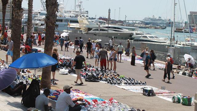 Un grupo de 'manteros' venden en el puerto de Barcelona. / EFE