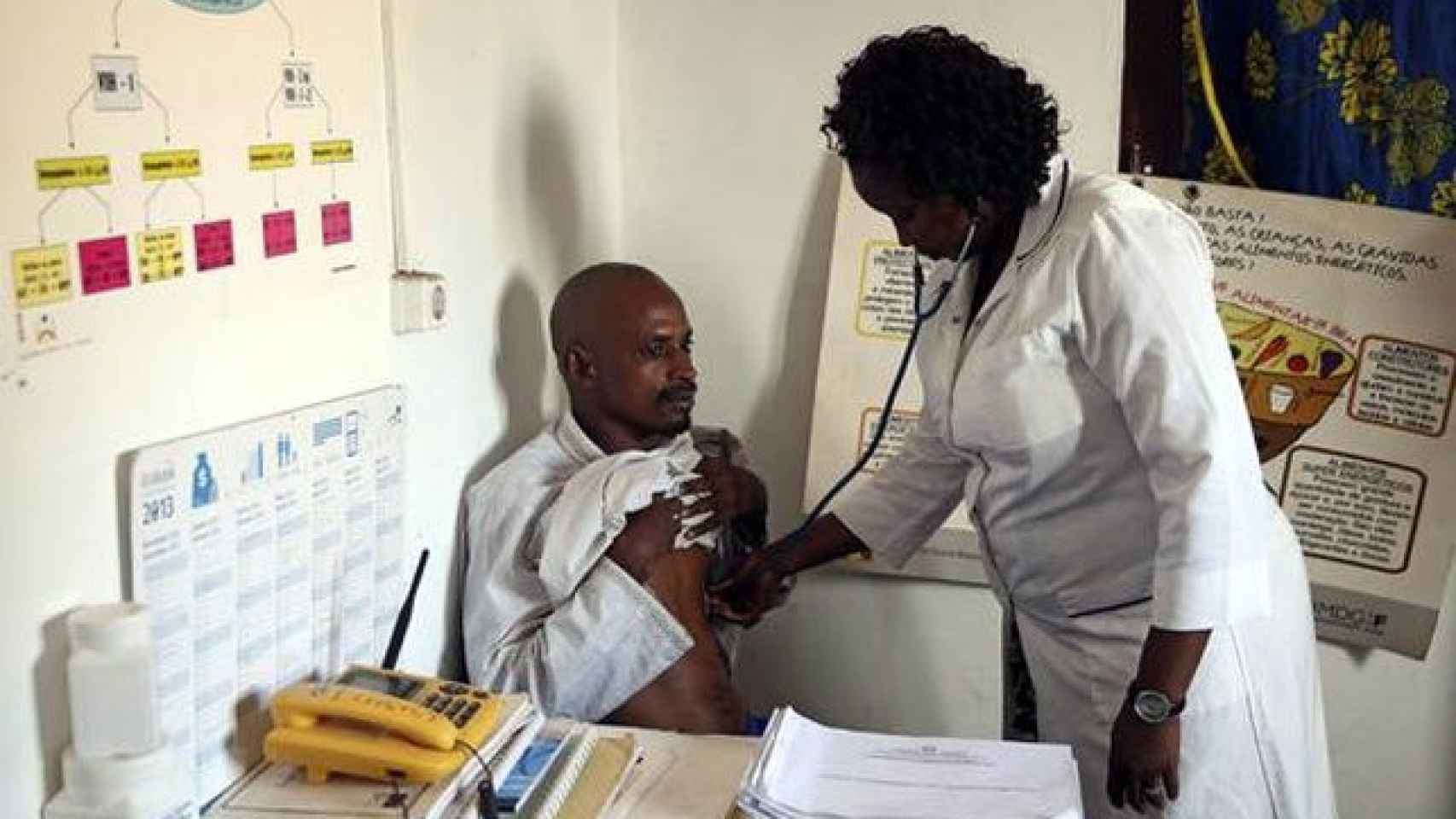 La enfermera guineana Egidia Almeida (der) osculta a un ciudadano procedente de Guinea Conakry en un centro médico a la entrada fronteriza de Buruntuma (Guinea-Bissau)