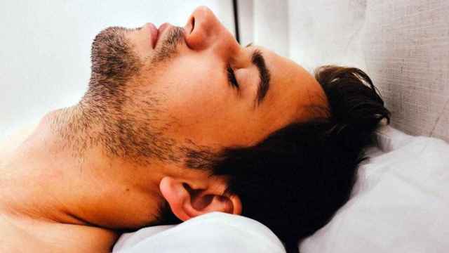 Un hombre duerme en una mala postura, lo que le puede provocar cansancio y dolor al despertar