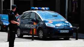 Imagen de un agente de la Policía Nacional ante un coche patrulla / EFE