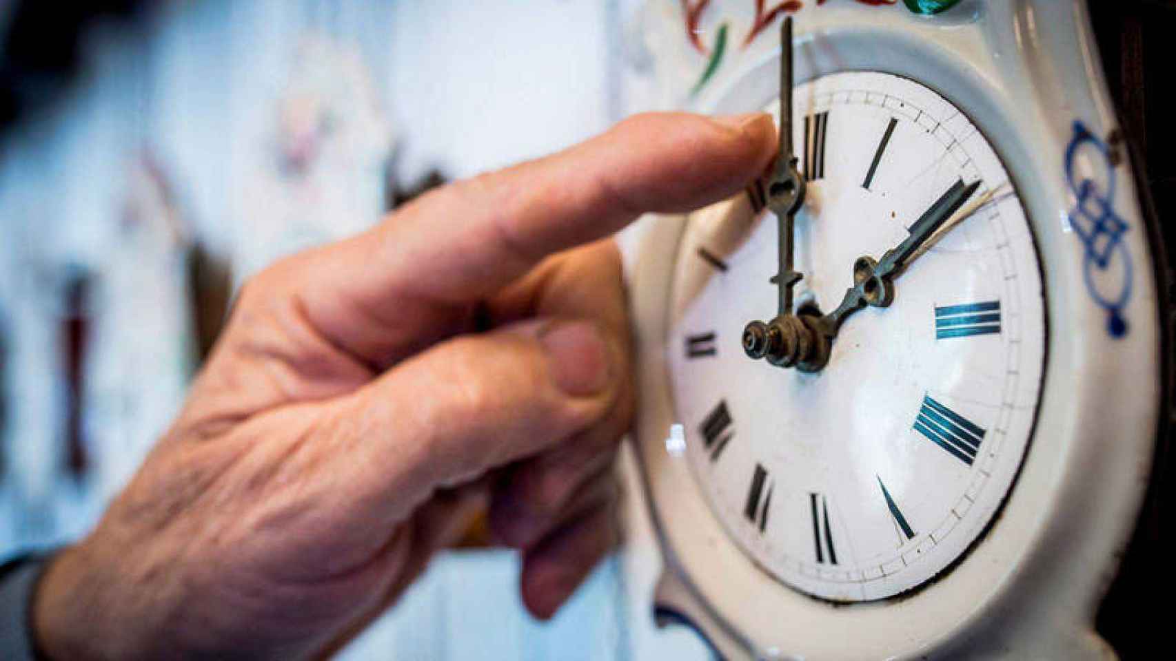 Un hombre cambia la hora de un reloj de forma manual / EFE