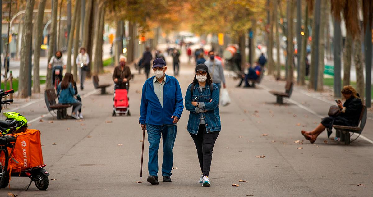 Un adulto mayor pasea junto a una mujer por La Diagonal de Barcelona / EFE