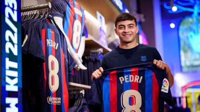 Pedri posa con la camiseta del Barça en una tienda oficial del club / FCB
