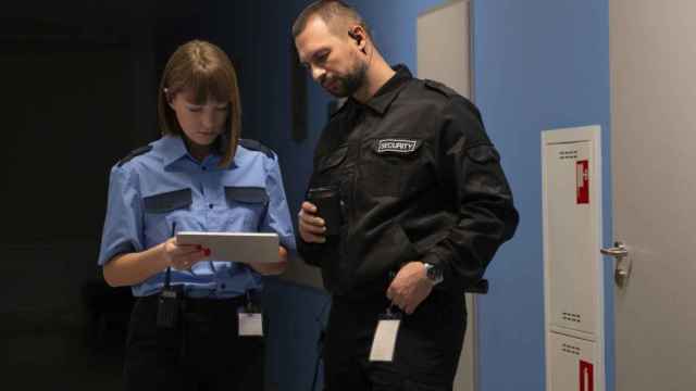 Dos miembros del personal de seguridad de una empresa comprueban datos