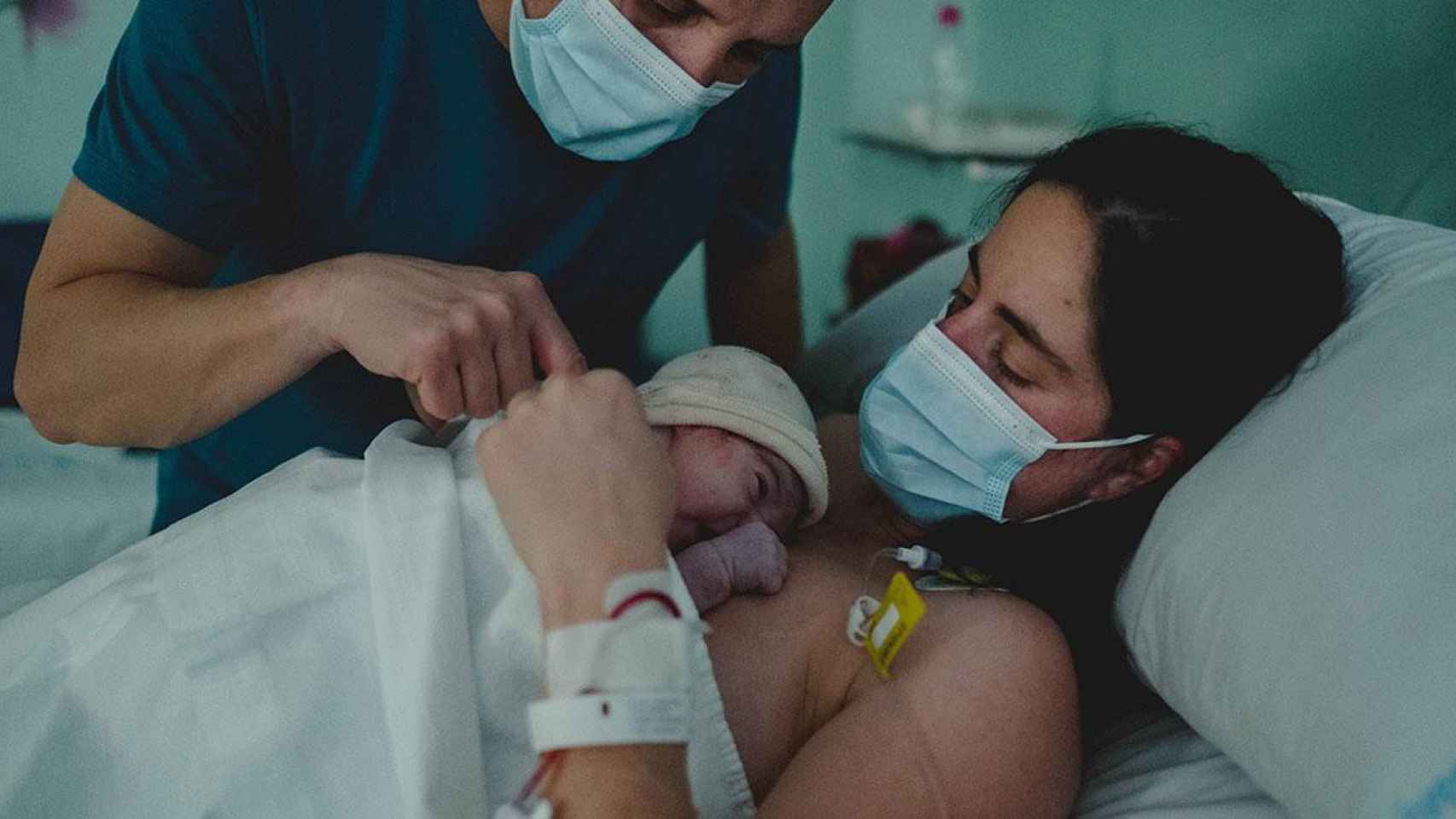 Una mujer observa a su bebé tras un parto