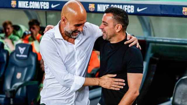 Guardiola y Xavi se saludan durante un amistoso entre City y Barça