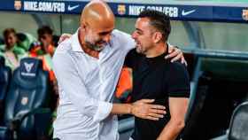 Guardiola y Xavi se saludan durante un amistoso entre City y Barça / FCB