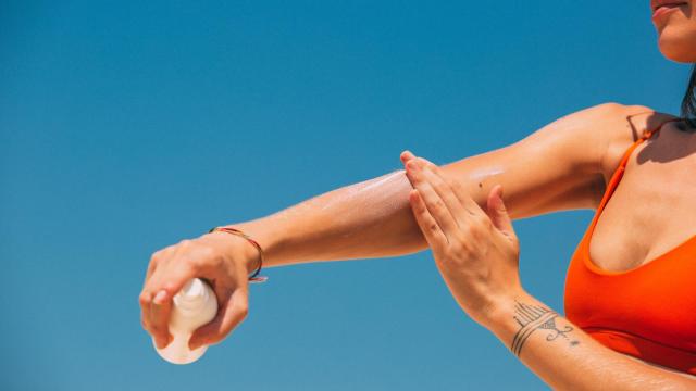 Una mujer se aplica crema solar para protegerse del sol en la playa