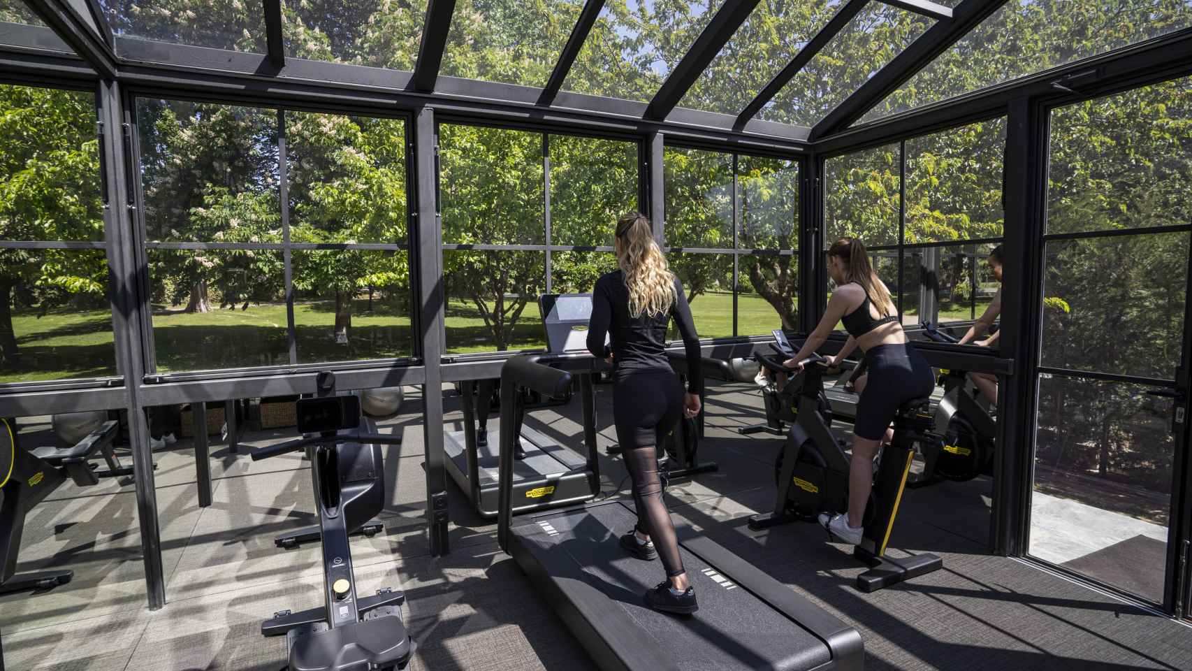 Dos huéspedes hacen deporte en el gimnasio del Hotel Serras Torre del Remei