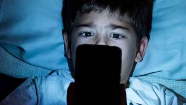 Un niño mira la pantalla de su teléfono móvil