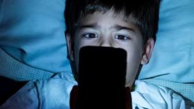 Un niño mira la pantalla de su teléfono móvil