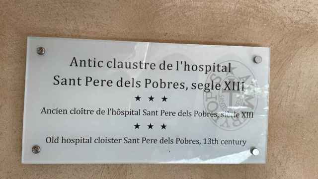 Cartel en tres idiomas del antiguo claustro del hospital de Sant Pere dels Pobres en Aiguamúrcia, Tarragona
