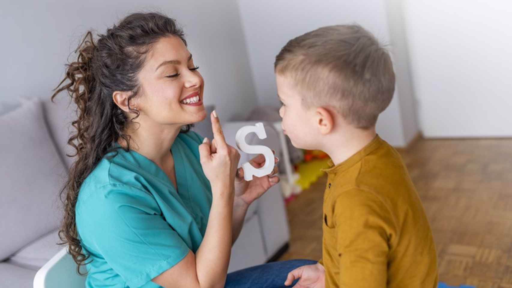 Una logopeda enseña a hablar a un niño