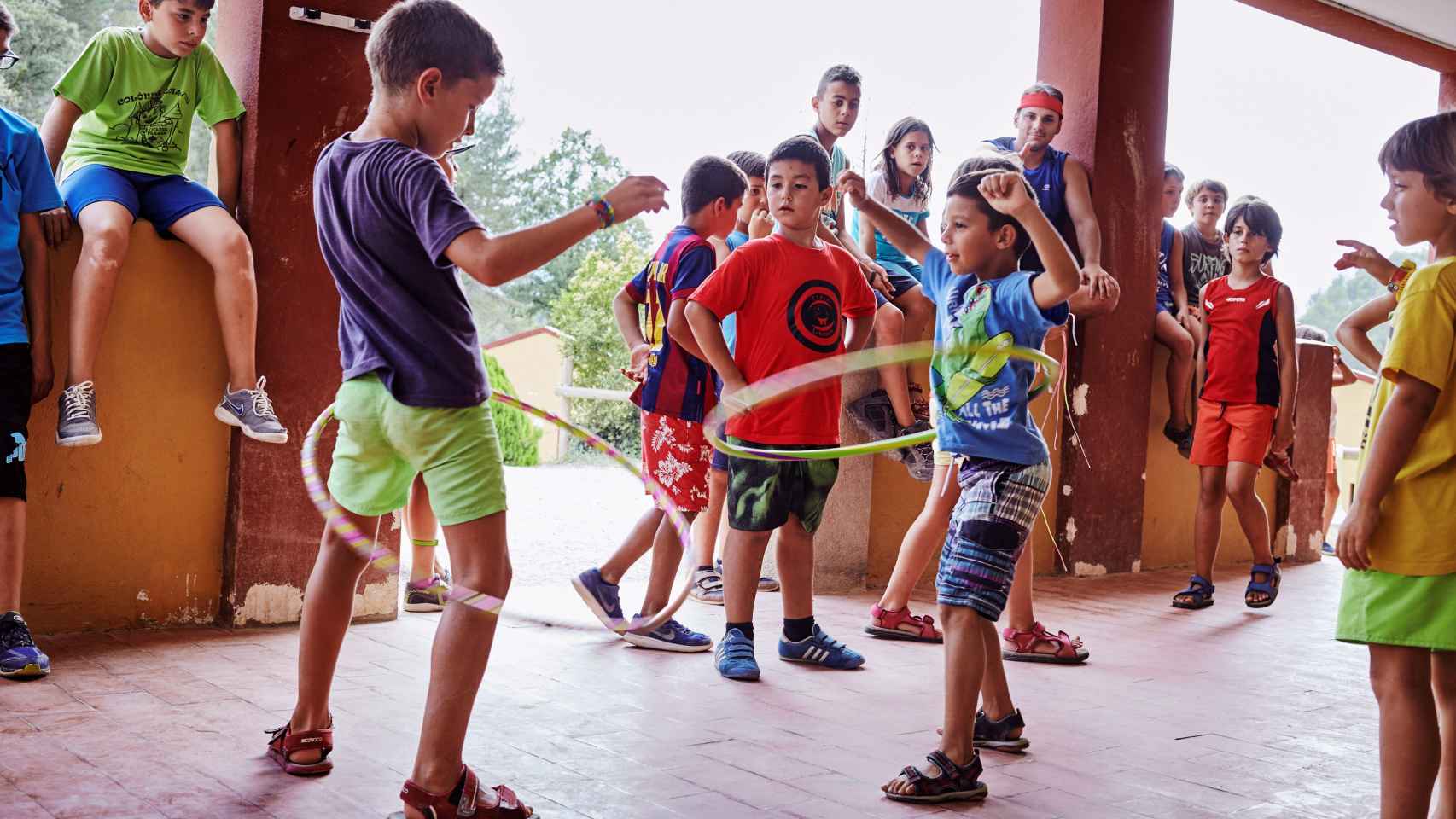 Un grupo de niños juega al hula hoop en un campamento de verano