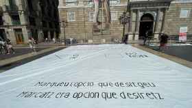Pancarta reproduciendo una papeleta del  referéndum ilegal del 1-O desplegada en la plaza Sant Jaume de Barcelona