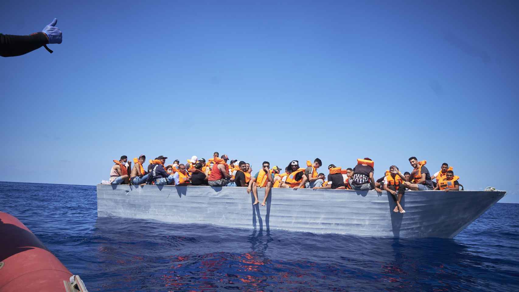 Varios de los migrantes que viajan en una patera avistada por la ONG Open Arms desde el barco 'Astral', a 8 de septiembre de 2021, en el Mar Mediterráneo