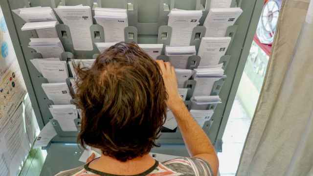 Una persona dentro de una cabina electoral para coger su papeleta