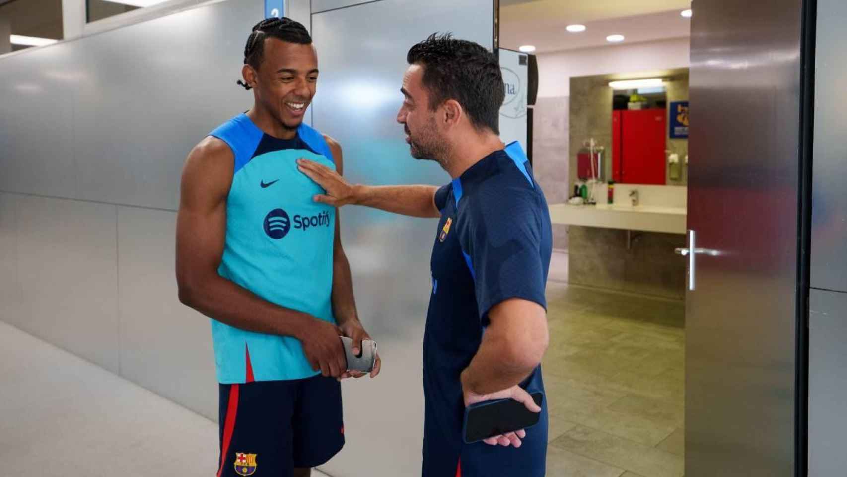 Jules Koundé y Xavi Hernández, antes de un entrenamiento con el Barça
