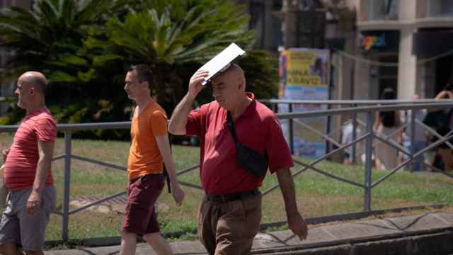 Una persona trata de protegerse del sol en Las Ramblas, a 18 de julio de 2023, en Barcelona,