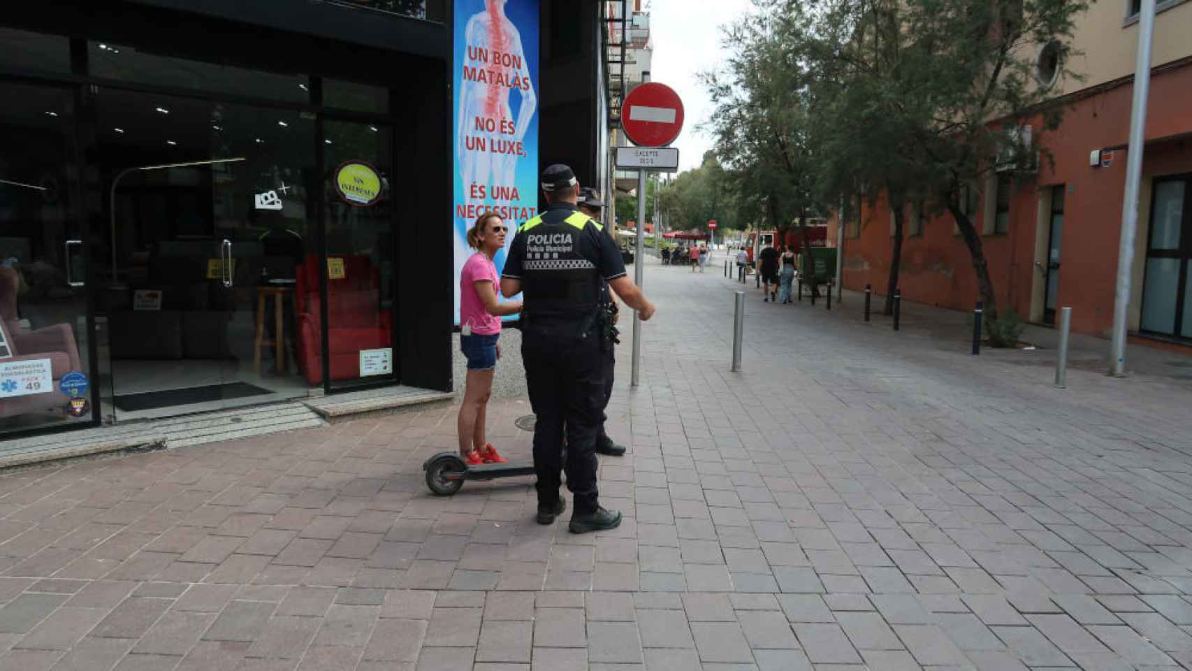 Un agente de la Policía Municipal, hablando con una ciudadana