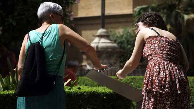 Dos mujeres recoge agua de una fuente para combatir la ola de calor