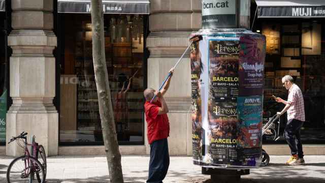 Un operario pega carteles en Barcelona