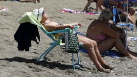 Una mujer tomando el sol en la playa
