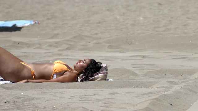 Una mujer toma el sol en la playa