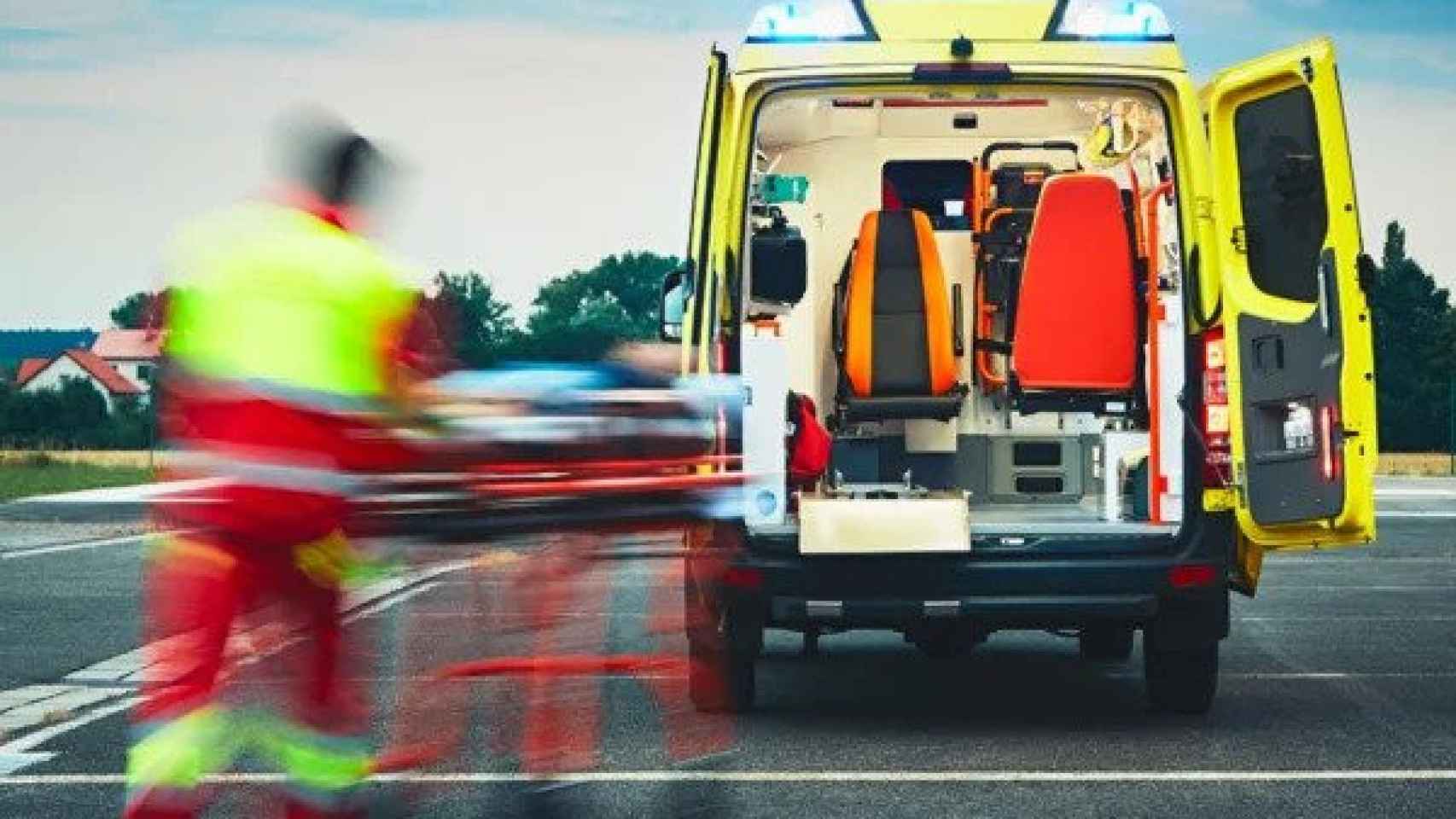Imagen de un técnico de transporte sanitario ante una ambulancia