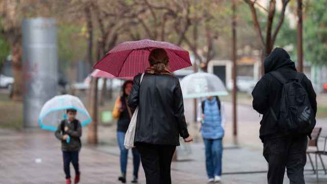 Varias personas con paraguas pasean por una de las calles de la ciudad, a 12 de mayo de 2023, en Barcelona