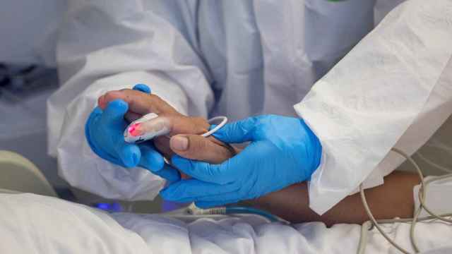 Un sanitario coge de la mano a un paciente