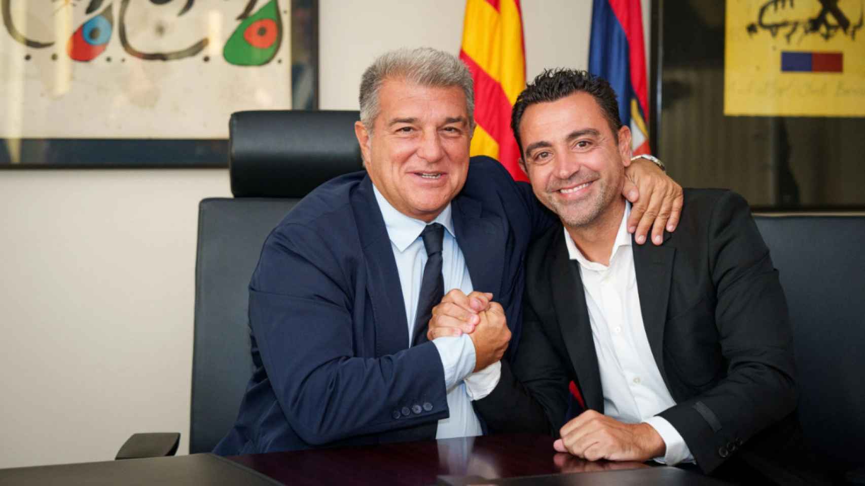 Xavi Hernández y Joan Laporta se abrazan tras firmar la renovación del técnico del Barça